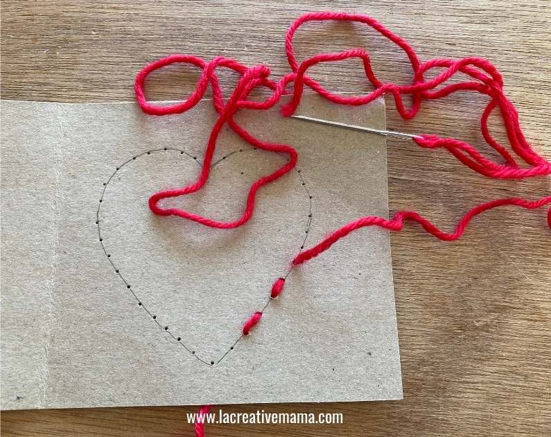 sewing a running stitch on a valentines handmade card