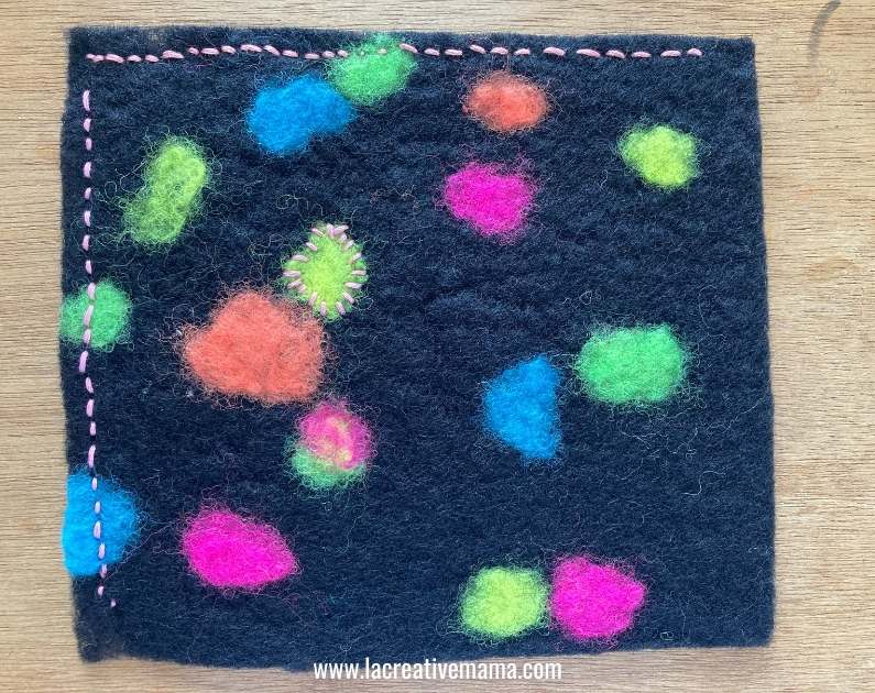 decorating a  piece of felt with embroidery stitches 