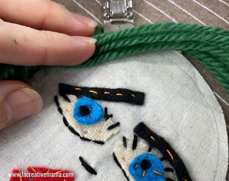 sewing the wool hair on the fabric face 