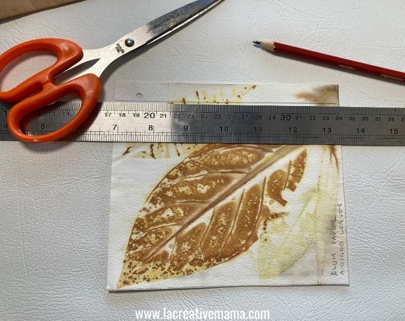 measuring and cutting the paper card to glue it on the paper bag
