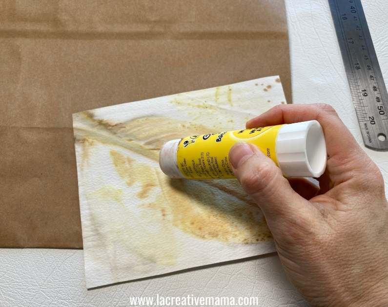 gluing the eco printed paper on the bag using a glue stick 