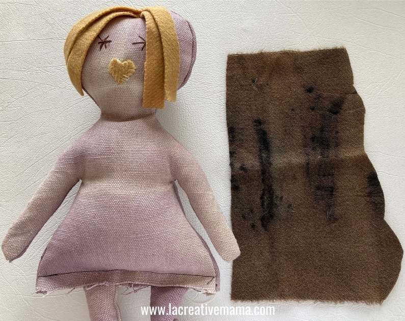 adding the brown felt hat to the doll 