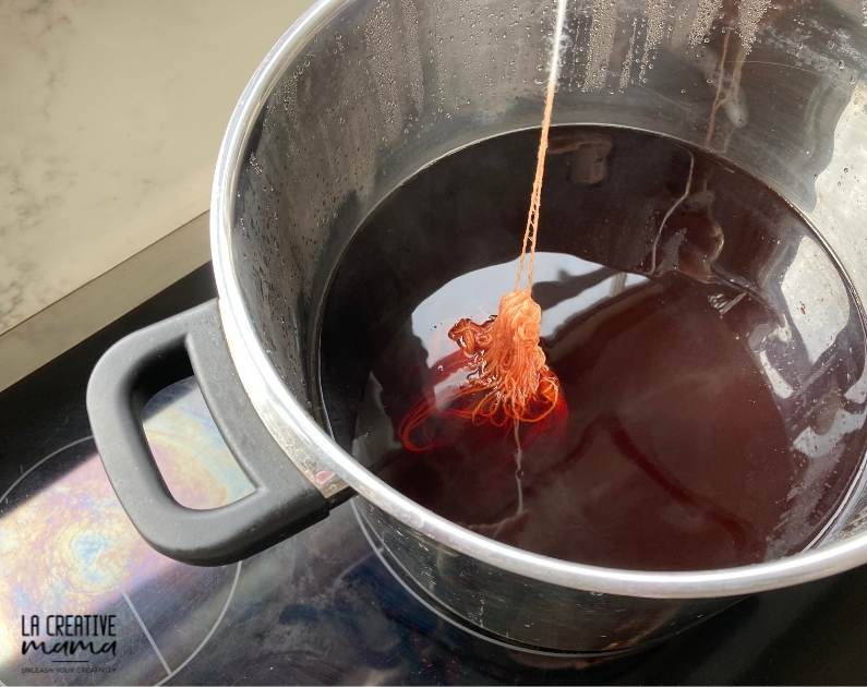 a wool skein being immersed in a dye solution 