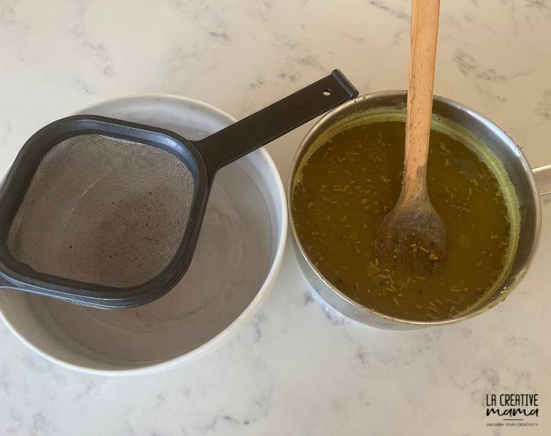 straining a mate dye bath using a metal strainer 