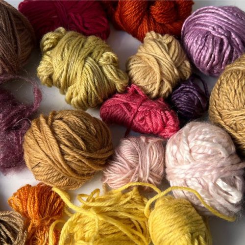 a variety of bright reds, pinks, yellows and purples on naturally dyed wool yarn using natural dyes